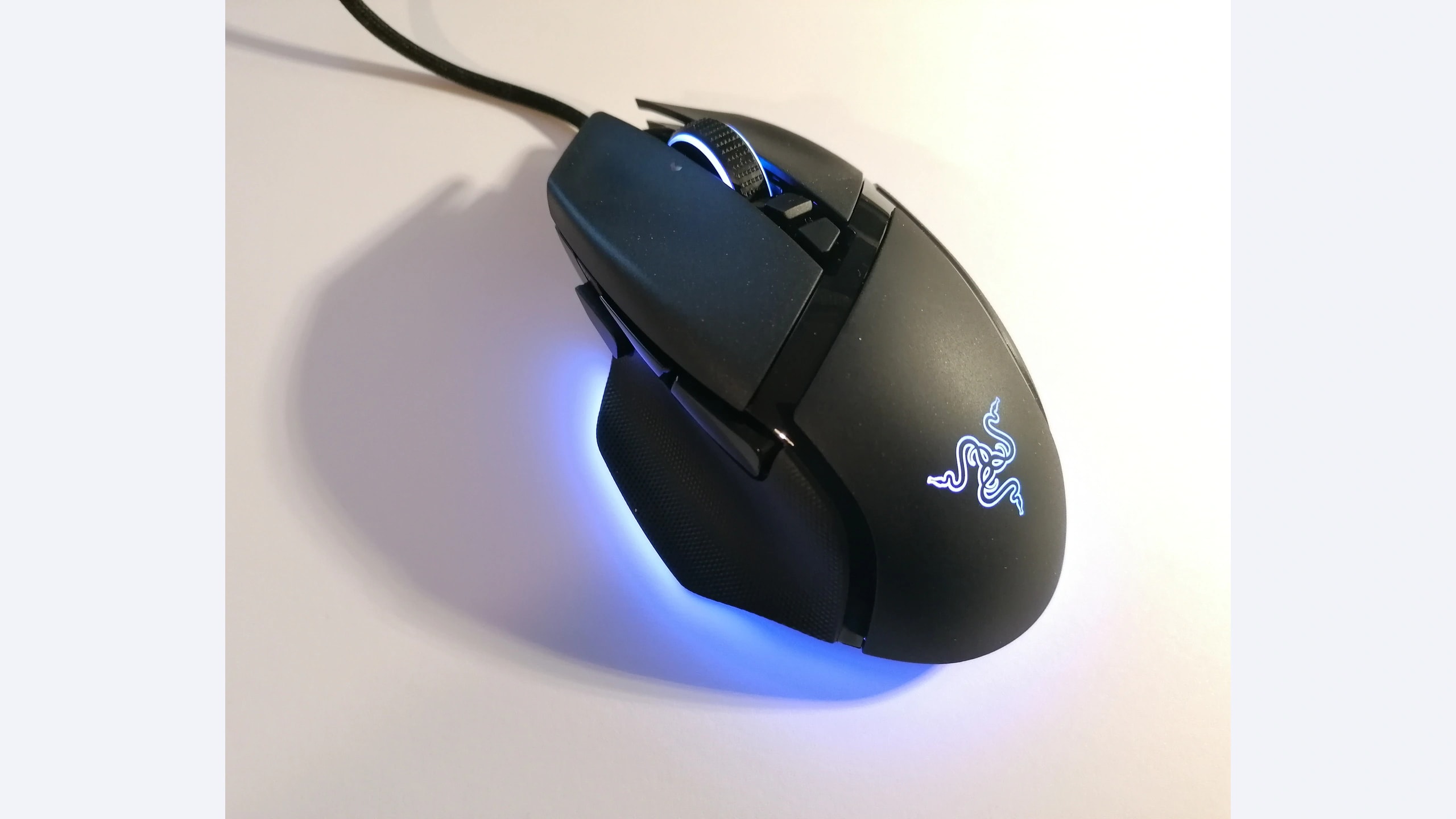 Razer Basilisk V3 wired mouse with its thumb rest and illuminated logo visible